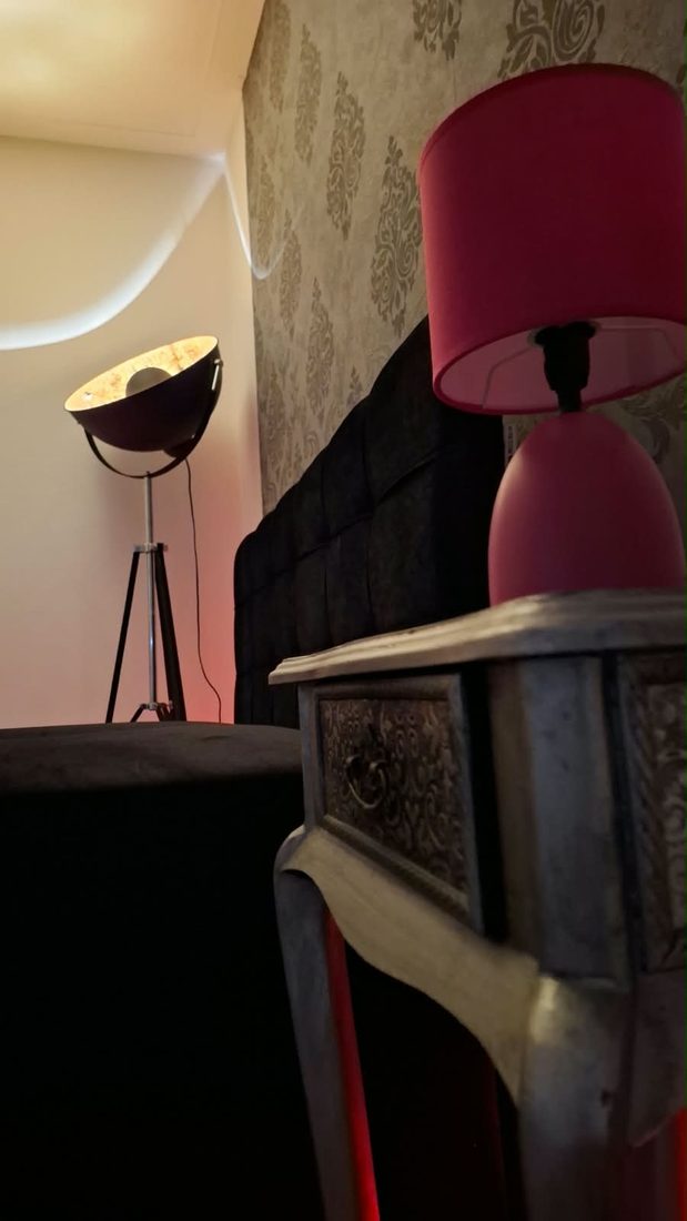 Studio-Stehlampe, Nachttisch und rosa Lampe vor Ornamenttapete