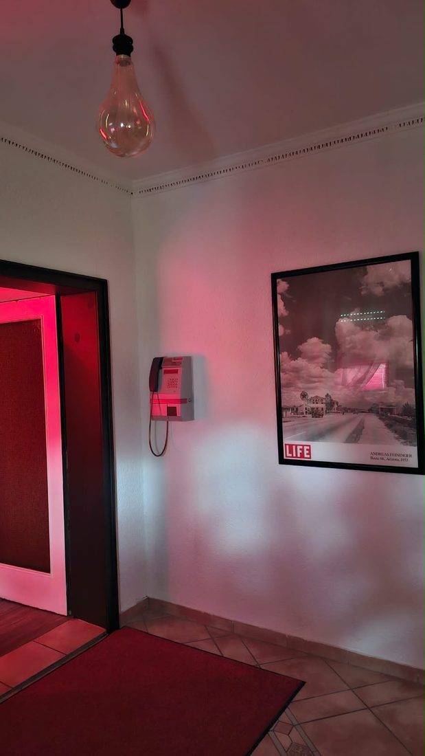 Diele mit altem Münztelefon und Schwarzweiß-Fotografie