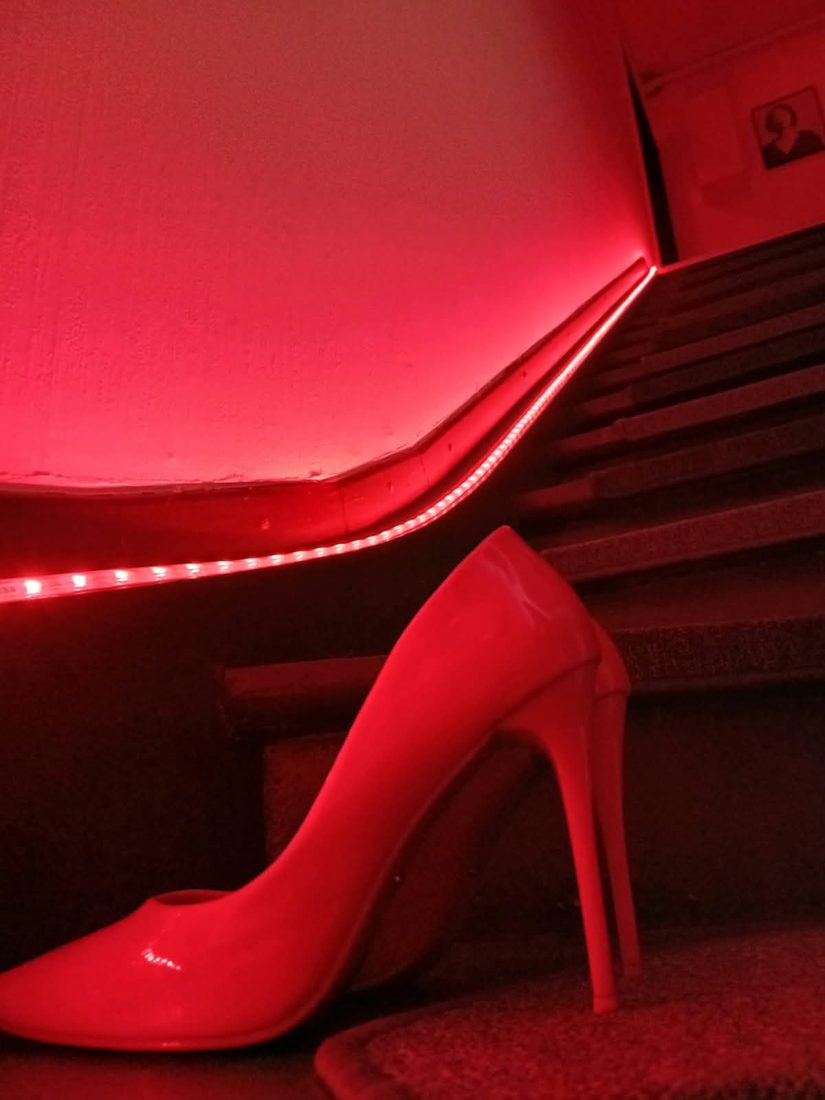 Roter Lackpump auf der beleuchteten Treppe