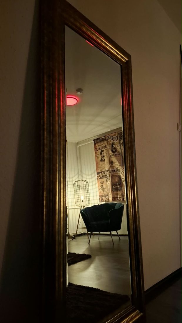 Goldener Spiegel, in dem sich die Sitzecke spiegelt